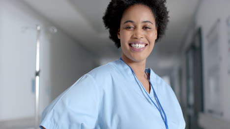 smiling african american nurse in a hospital corridor, with copy space