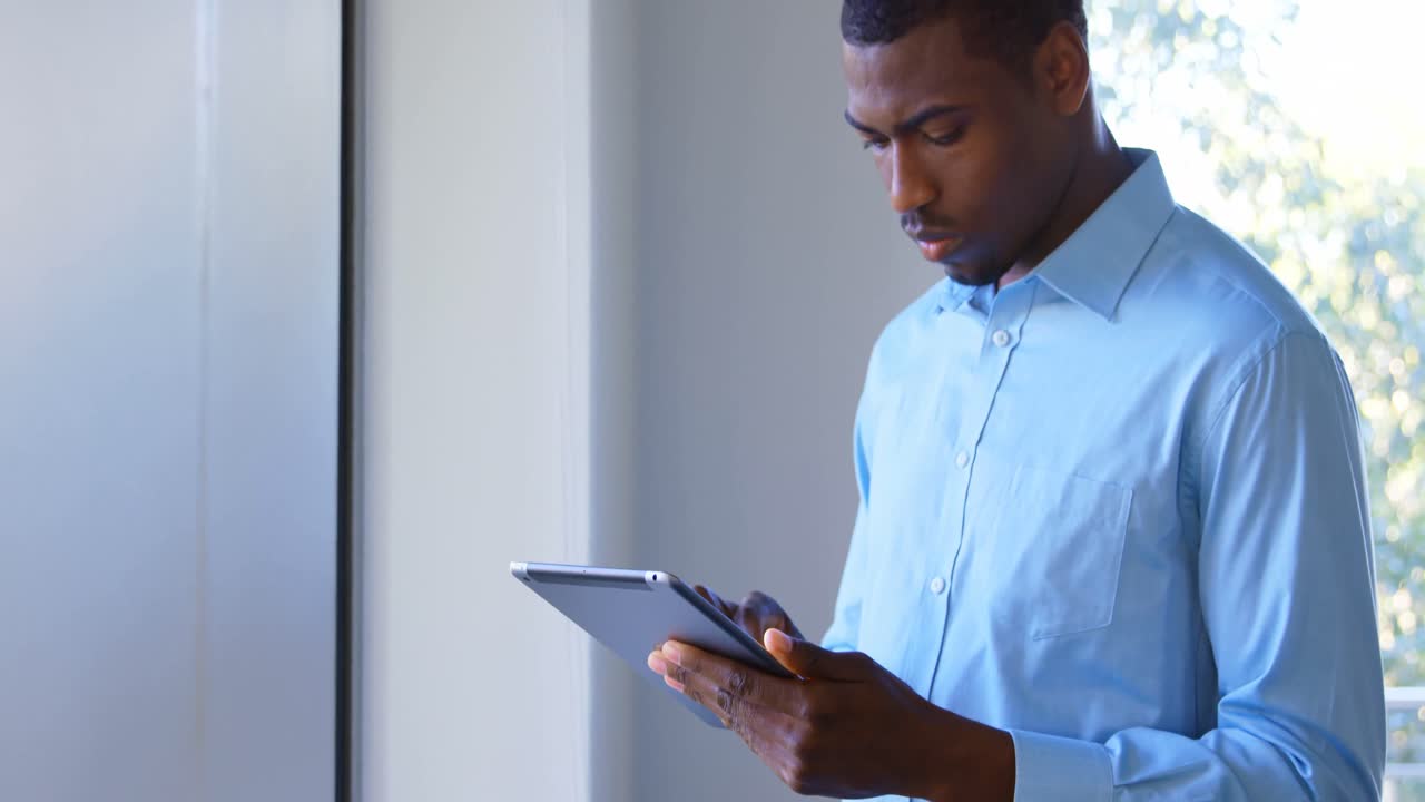 Young black male executive working on digital tablet in modern office 4k