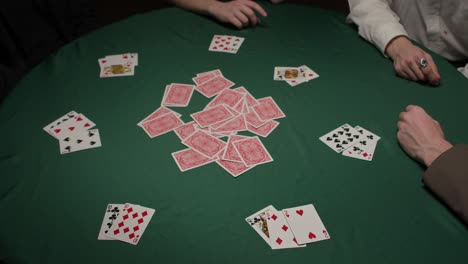 group of gamblers grab cards in a dark moody casino