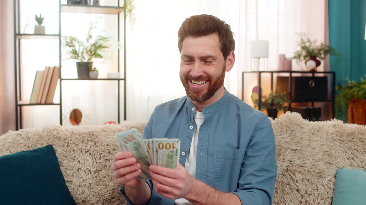 Man met een stapel dollarbiljetten die geld telt en glimlacht, blij met de hoge inkomsten