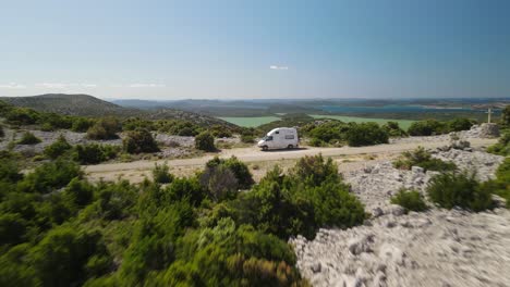 Aerial-forward-and-over-a-vehicle-with-an-amazing-landscape-view-of-Naturpark-Vransko-Jezero,-Vrana-Lake-Nature-Park,-Croatia