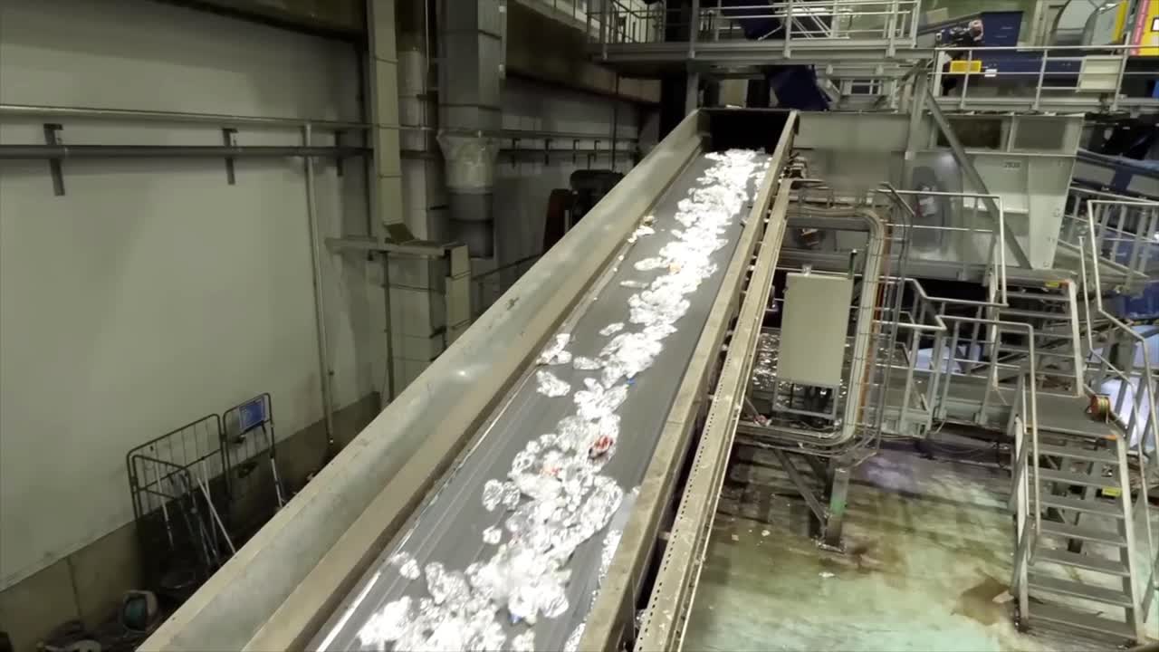 Used plastic bottles move along a conveyor belt for processing.
