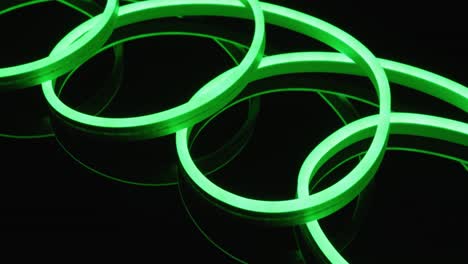 Animation-of-green-neon-lights-forming-spiral-over-black-background