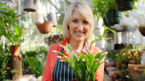 portrait of mature woman holding pot plant