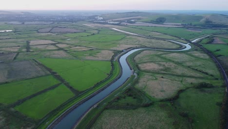 picturesque valley with curving river and railway in east sussex, england