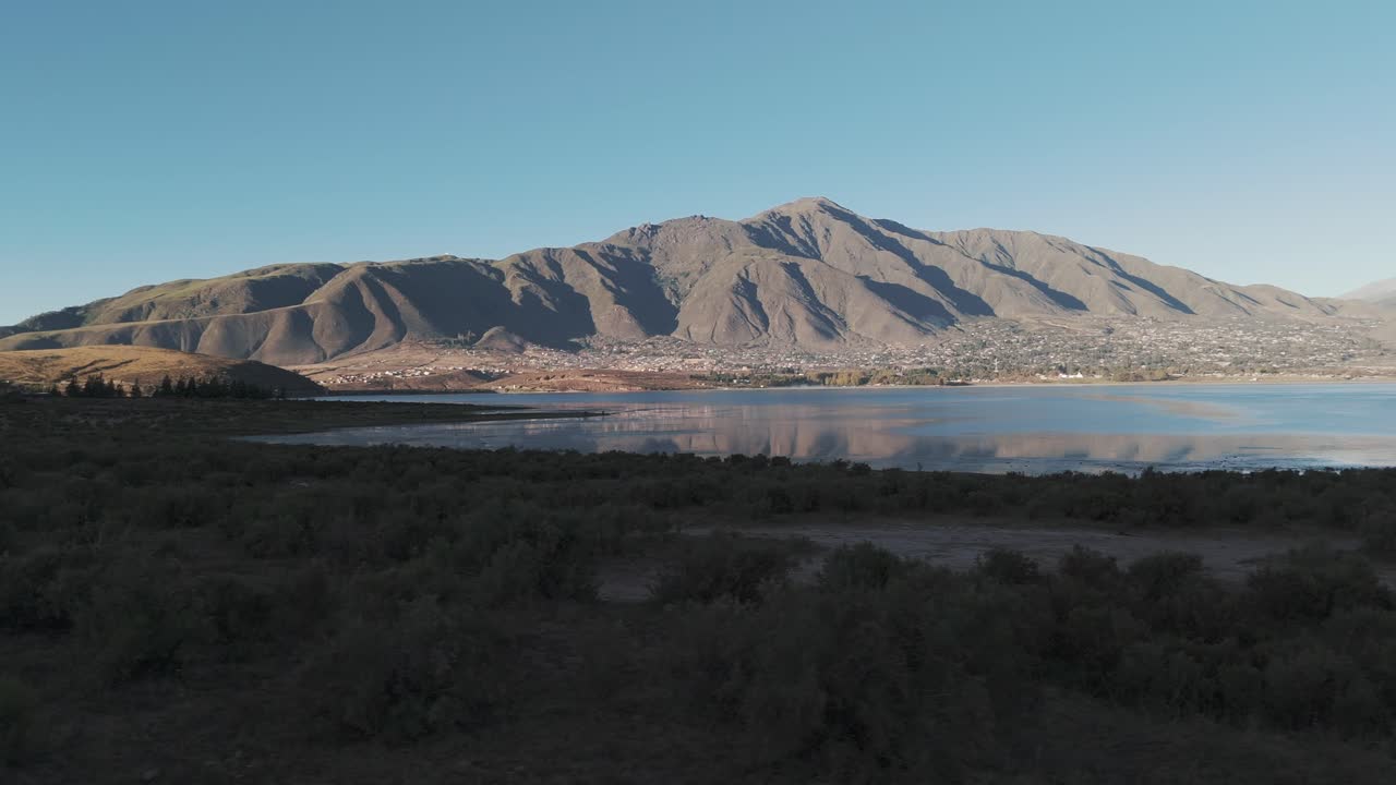 pan aérea con vistas al agua en el paisaje desértico con montañas más allá del agua en la distancia