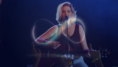 teenage girl strumming acoustic guitar, singing into mic on music stage with neon swirl effects
