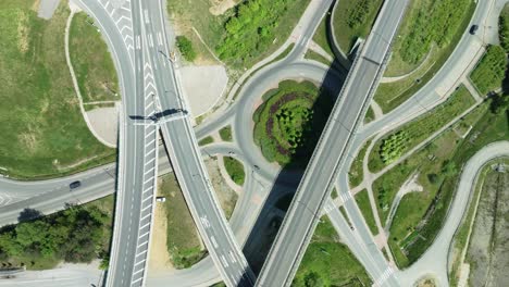 Static-aerial-drone-footage-showcases-a-transportation-themed-scene:-intricate-highway-junction-with-cars-navigating-roundabouts-and-intersecting-roads