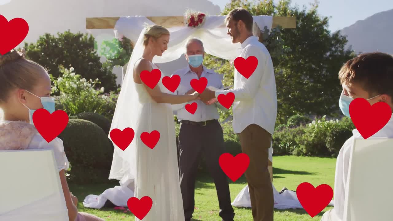 анимация красных сердец над различными людьми, носящими маски на свадьбе