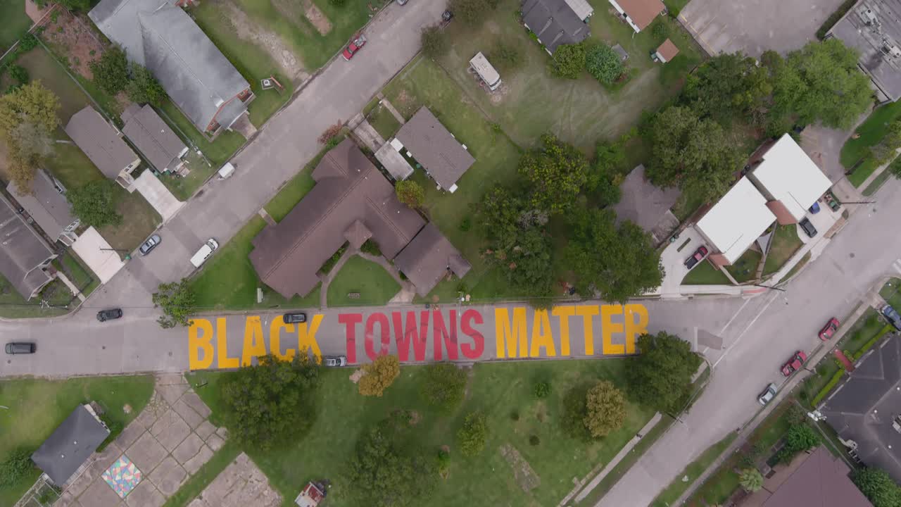 Bird eye view of a large "Black Towns Matter" sign painted on street in Houston Historical independence Heights district