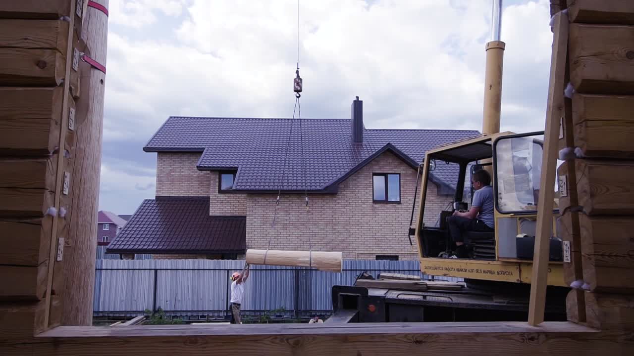 크레인과 노동자들과 함께 로그 캐비 건설
