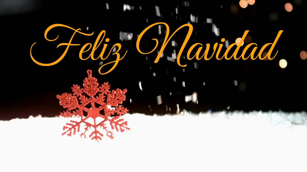 feliz navidad escrito sobre la nieve que cae