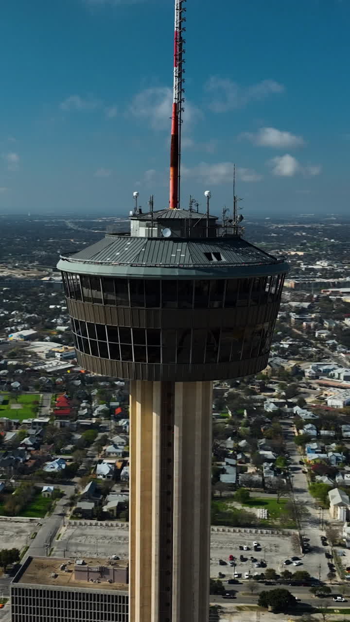 Vertical drone shot circling the Tower of the Americas, sunny day in San Antonio