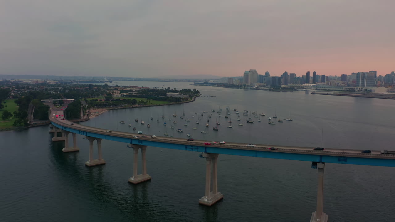 석양에 캘리포니아 샌디에고 베이에서 코로나도 다리와 보트의 공중보기 - 드론 샷