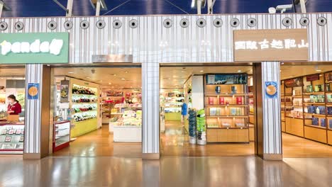 people passing by a well-lit airport shop