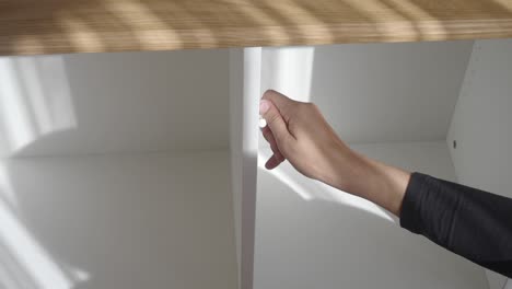 person opening a white cabinet drawer