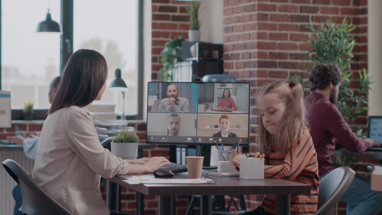 Single mom with child at work attending video call meeting on computer