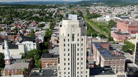 concrete skyscraper tower building, aerial reveal truck shot, downtown business financial district in reading, pa usa, church, housing, factory, businesses, homes, wide panorama