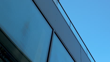 close-up of modern building's glass facade against blue sky