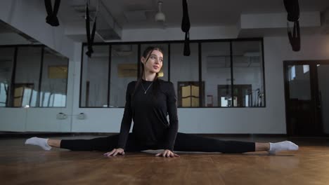 woman doing splits in a gym