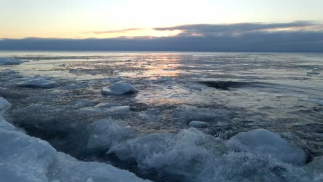 waves crashing on the shores of lake superior icebergs formations floting on the water winter morning