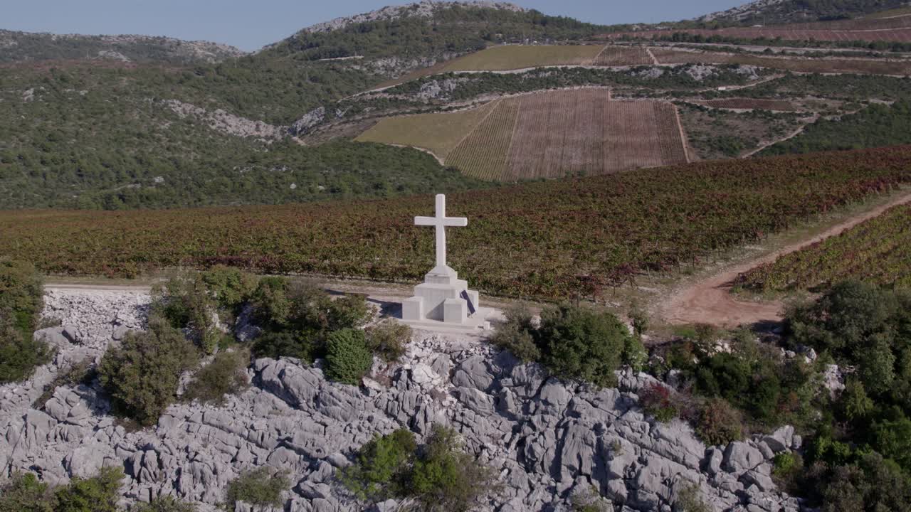 Vista aerea di un vigneto in collina con una croce su terreno roccioso, Slivno, Croazia