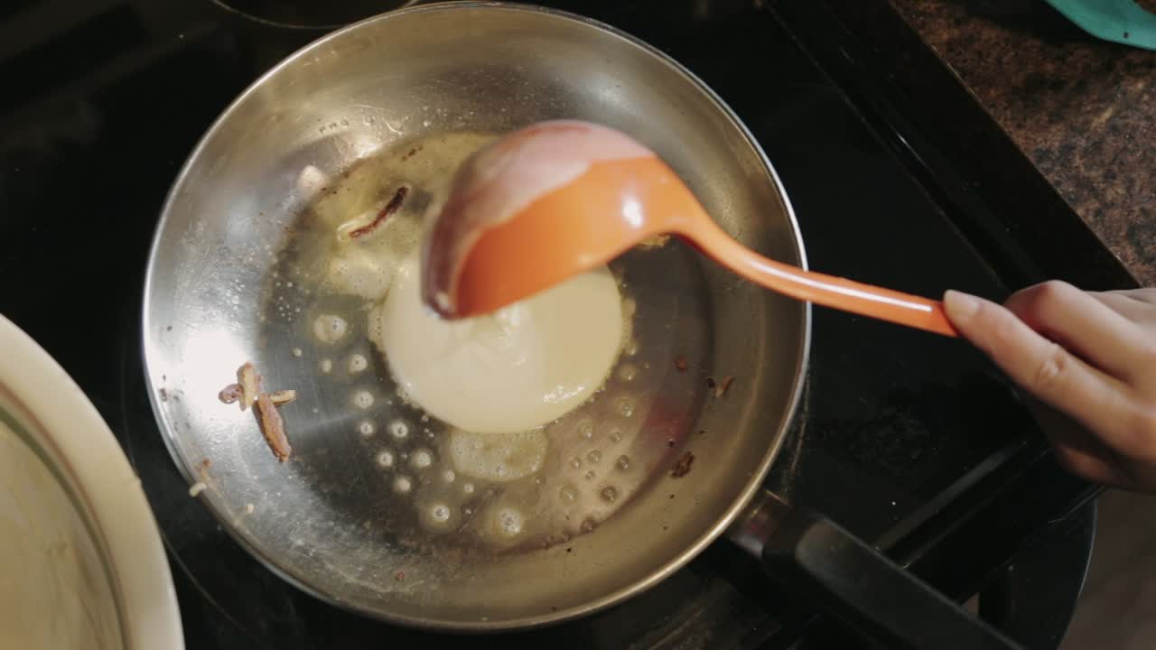 Canada - Putting Pancake Batter To A Stainless Pan With Melted Butter - Closeup Shot