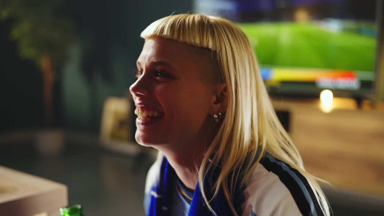 Excited Woman Watching Soccer Match on Television at Home