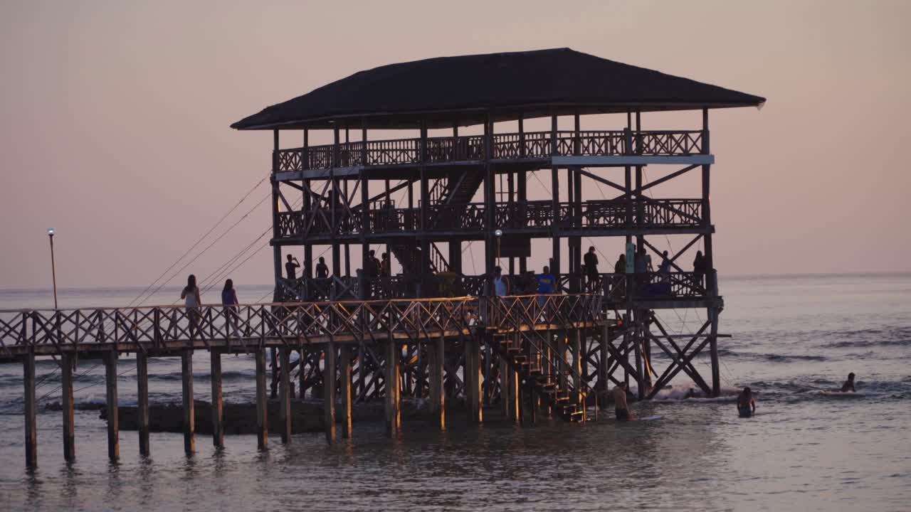 Panning right across the Cloud9 boardwalk with the sun low and out of frame, silhouetted against a cloudy sky, filmed in UHD 4K