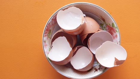 eggshells in a white  bowl on table ,