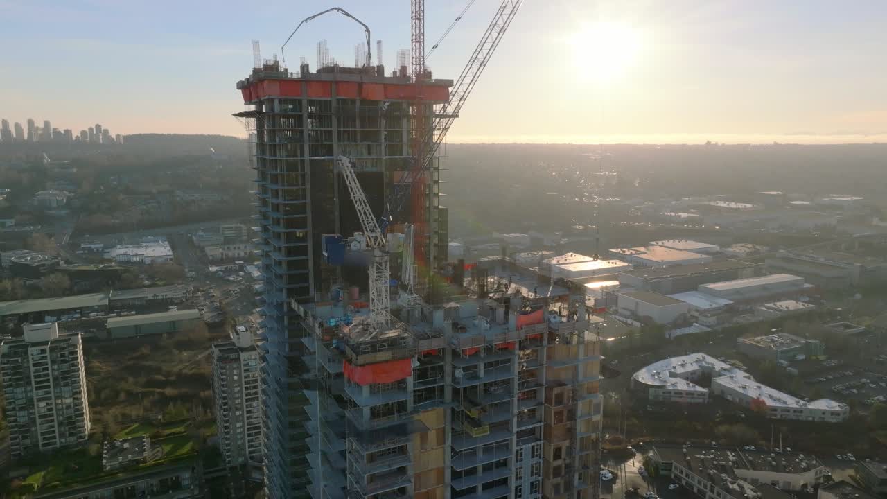 sitio de desarrollo de edificios de apartamentos altos con grúas en el trabajo en la azotea al atardecer en burnaby, columbia británica, canadá