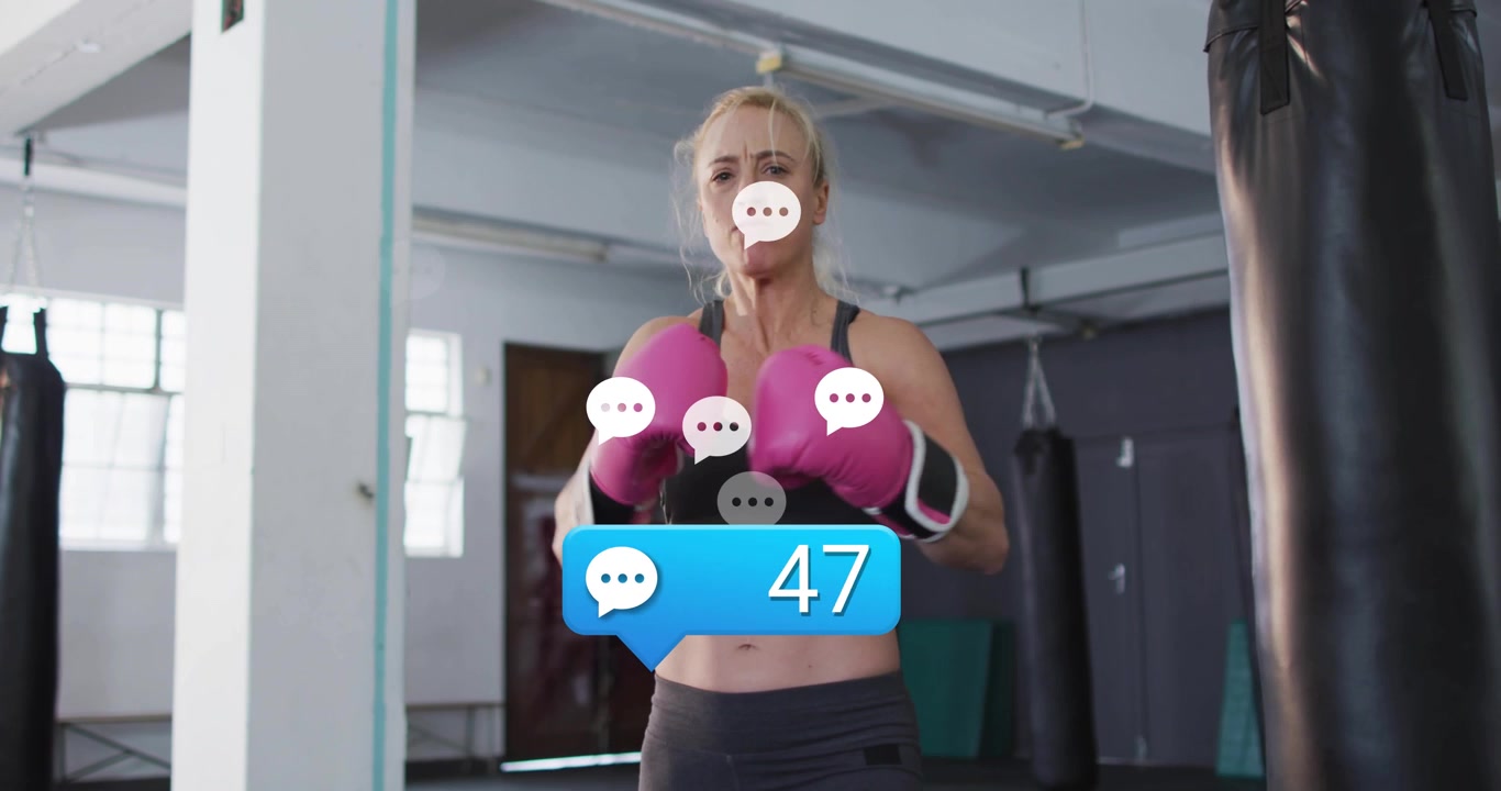 Donna che stringe i guantoni da boxe al sacco, attivando una bolla di commento sulla salute e regolando la postura