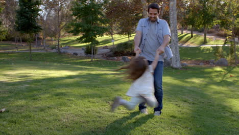 Padre-Hija-Balanceándose-Por-Sus-Brazos-En-El-Parque