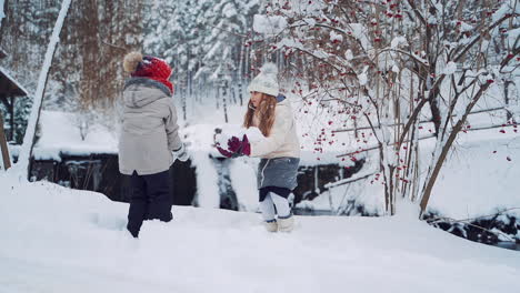 joyful children are throwing snow up on the background of winter river. little girls are playing with white snow in winter in the forest. slow motion.
