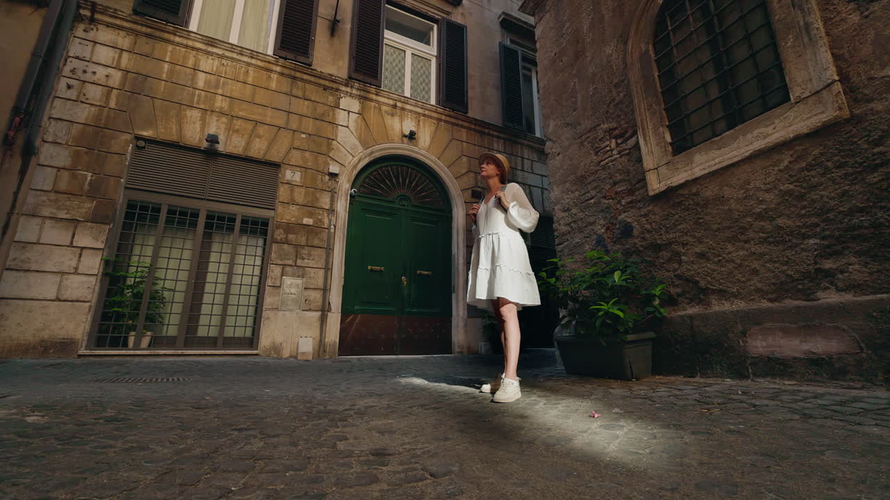 Woman in white dress on a cobblestone street