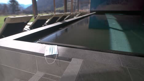 face mask next to a swimming pool in a hotel