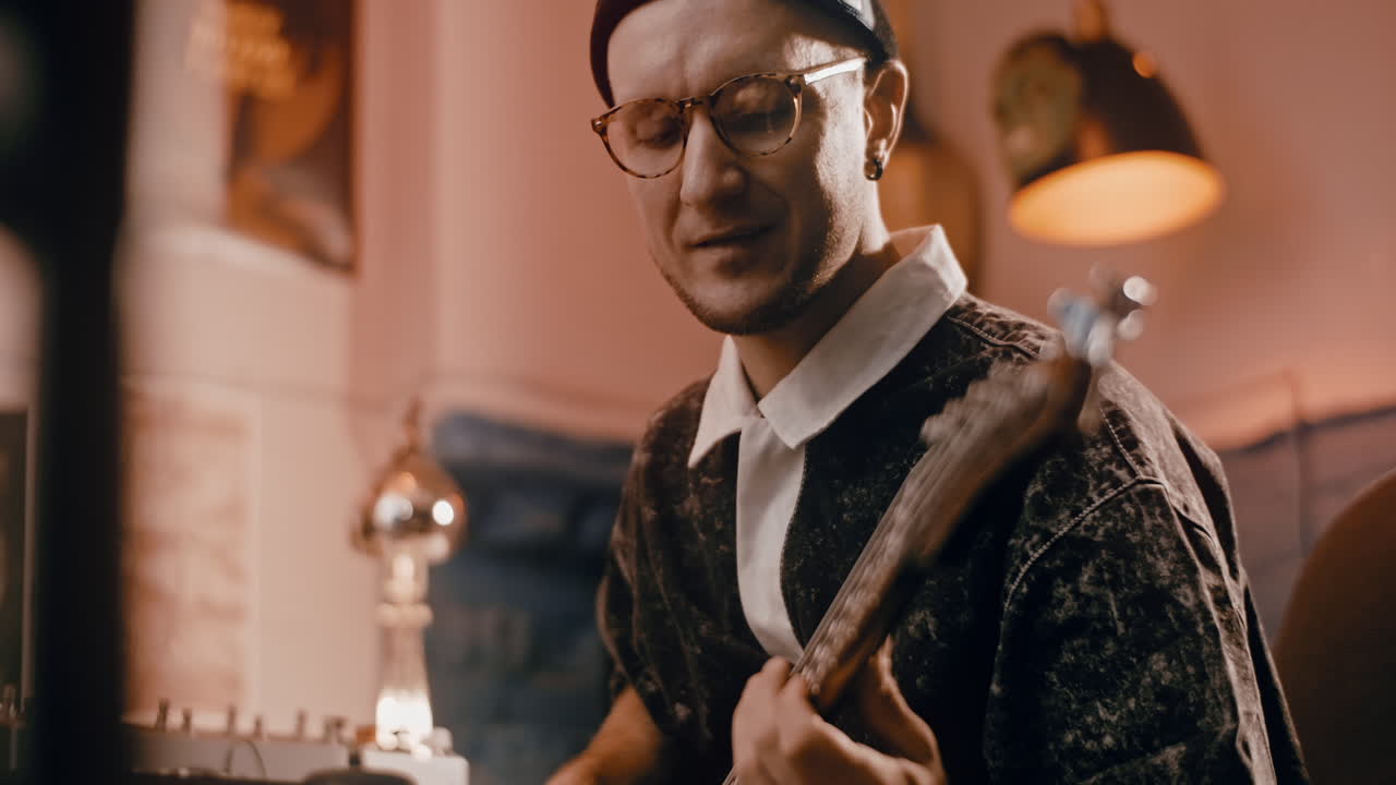 Man Playing Bass Guitar in Home Studio