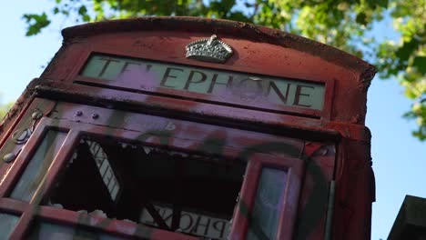cabina telefónica roja vandalizada después de los disturbios en la ciudad de londres