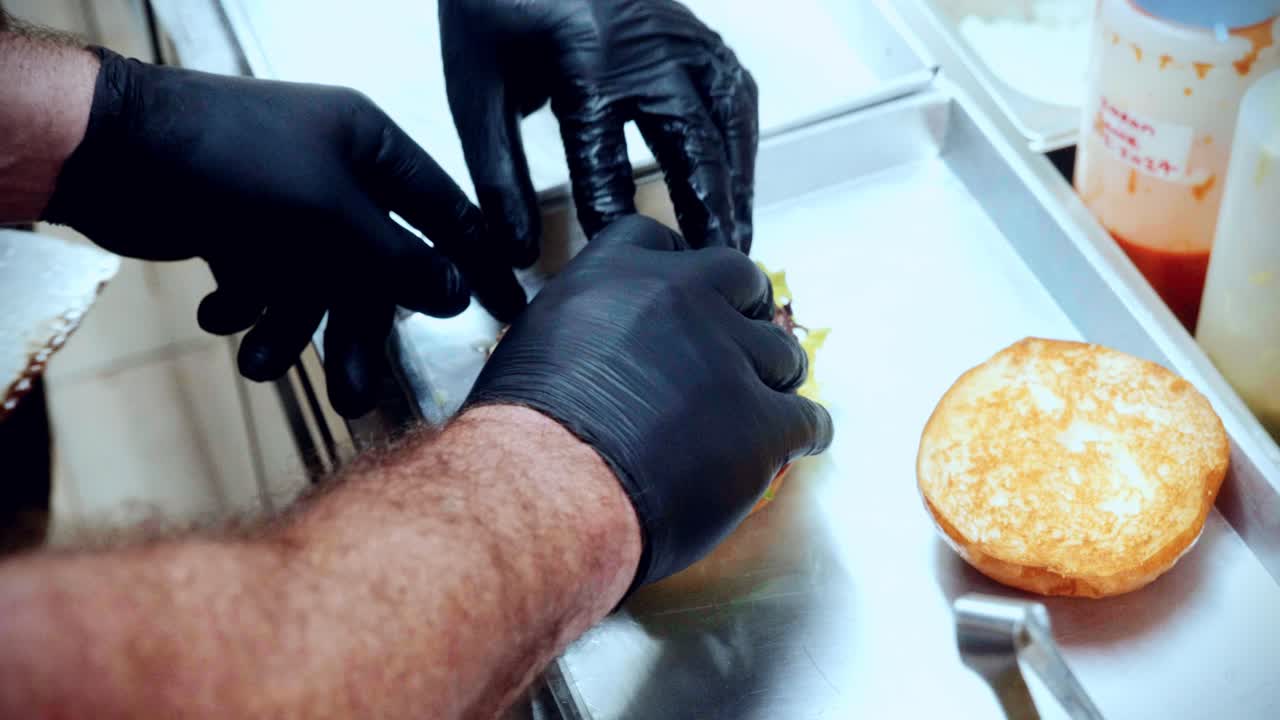 레스토랑 주방에서 맛있는 집에서 만든 햄버거를 준비하고 만드는 요리사의 4k 영화 음식 요리 영상.