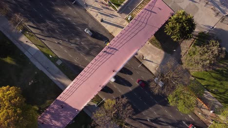 Aerial-top-down-of-driving-cars-on-road-and-students-crossing-bridge-path-in-direction-Law-School---Buenos-Aires,Argentina