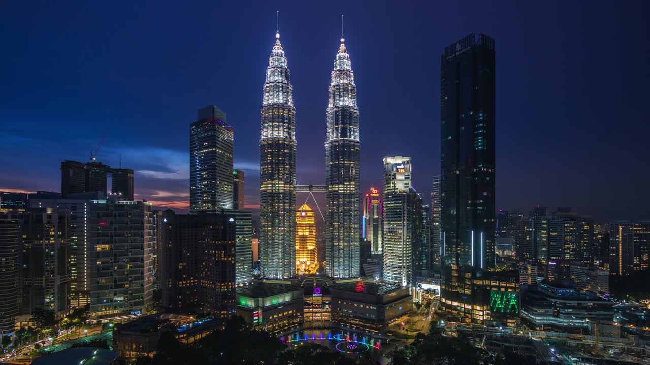 Vista en timelapse del anochecer a la noche del paisaje urbano de Kuala Lumpur, Malasia, con alejamiento