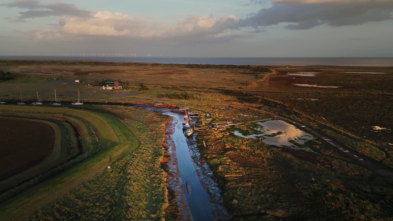 imágenes aéreas de drones de barcos atracados en el estuario con una increíble luz dorada del atardecer