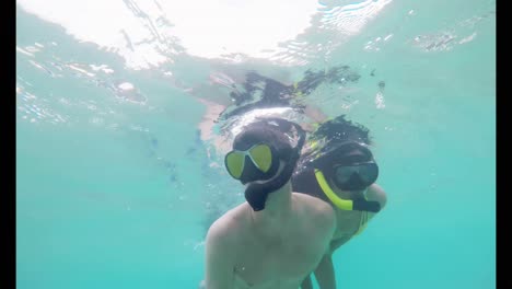 pareja buceando bajo el agua en el mar turquesa 4k