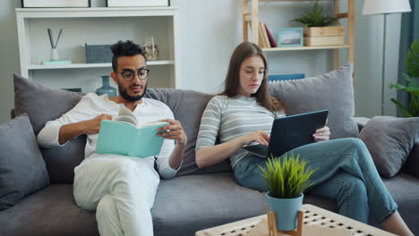 couple relaxing at home, reading and working
