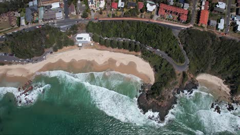 Vista-De-Arriba-Hacia-Abajo-Sobre-La-Playa-De-Flynns-Con-Un-Paisaje-Marino-Turquesa-En-Nueva-Gales-Del-Sur,-Australia---Disparo-De-Un-Dron