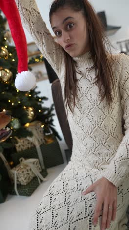 mujer y perro jugando con el sombrero de navidad