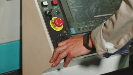 worker operating industrial machine controls