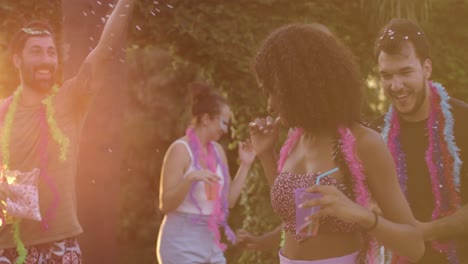 joyful friends celebrating carnival outdoors with confetti