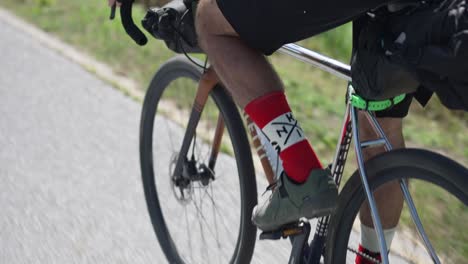 close up of man riding his bicycle on the road and spinning the bicycle chain