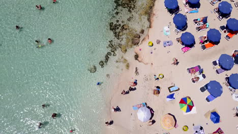 Luftaufnahmen-Von-Menschen,-Die-An-Einem-Flachen-Sandstrand-Baden